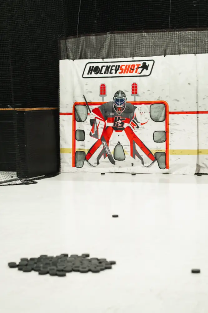 A pile of pucks in front of a shooting target